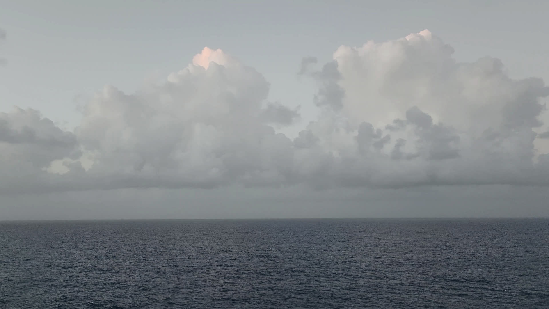 Grey sea under a clouded sky, the horizon low in the frame