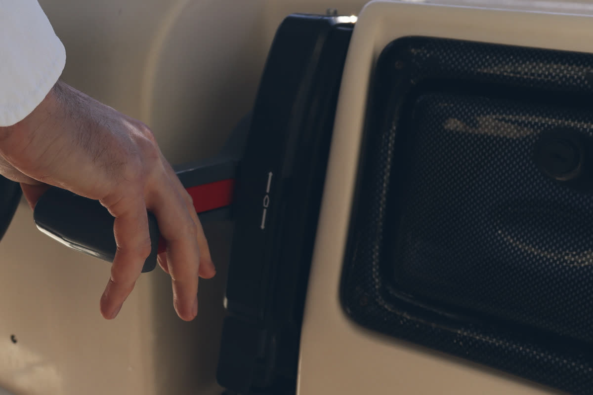 A hand on the throttle of a motorboat